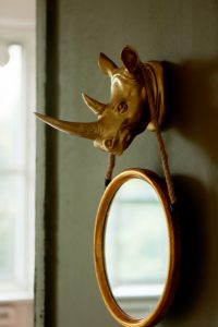 32703695-a-round-mirror-on-a-brown-and-gold-wall-hanging-on-the