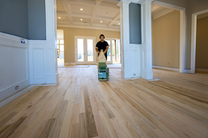 A process of grinding a wooden parquet floor by using a floor sander in a newly constructed house to ensure that it is smooth and even